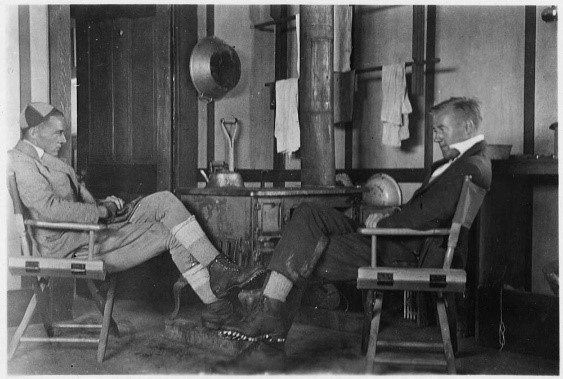 Two climbers by the stove in the hut
